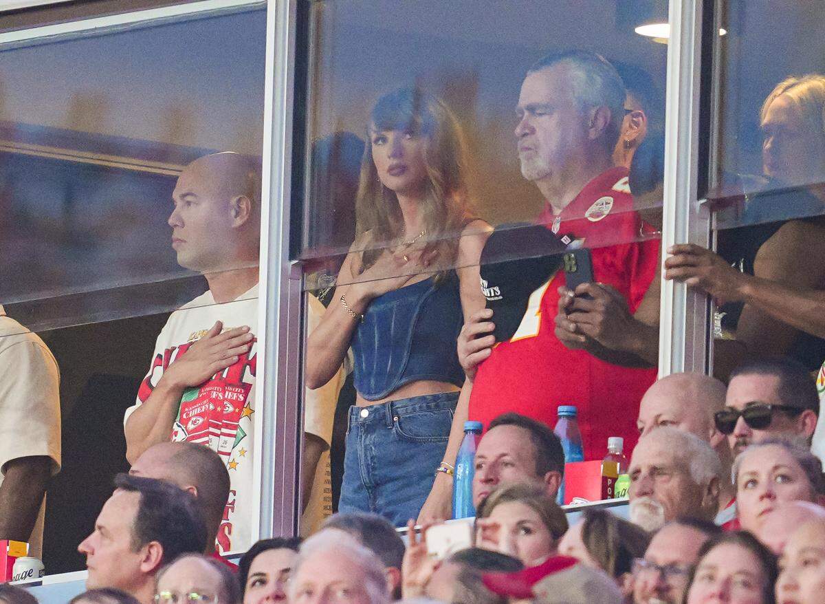 Superstar singer Taylor Swift observes the national anthem prior to a game between the Baltimore Ravens and the Kansas City Chiefs at GEHA Field at Arrowhead Stadium.