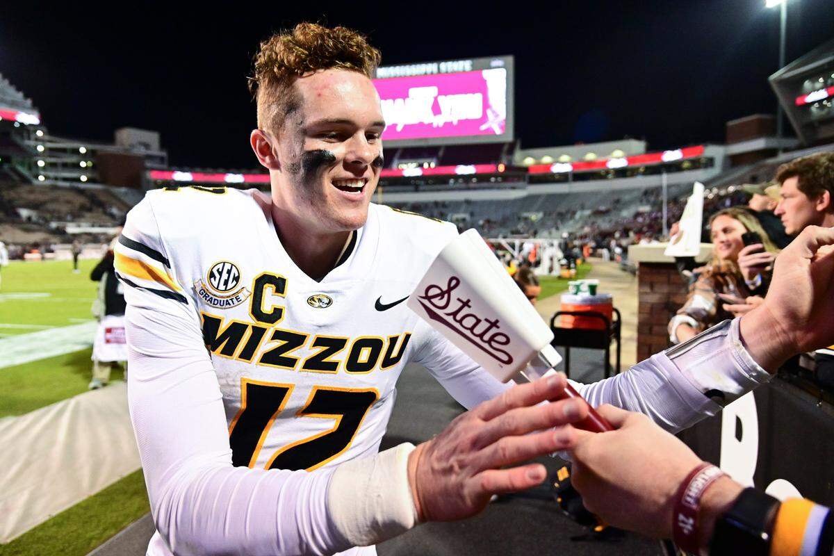 Missouri Tigers quarterback Brady Cook (12) is given a cowbell after a game against the Mississippi State Bulldogs at Davis Wade Stadium on Nov. 23, 2024.