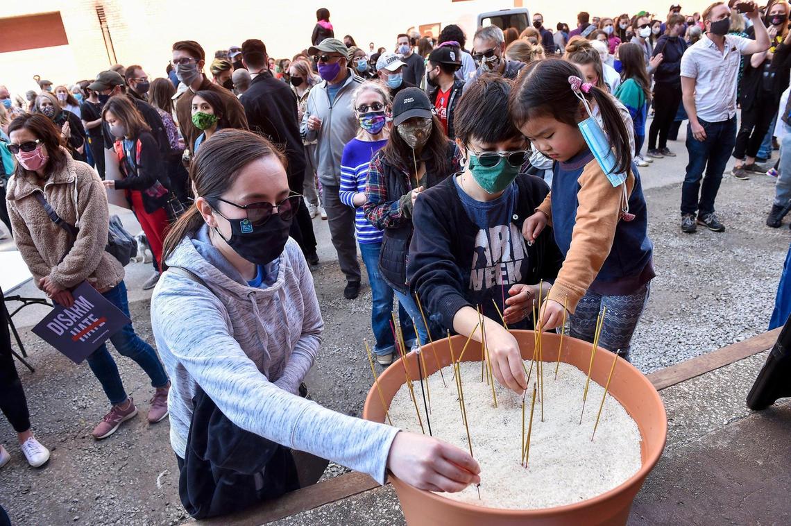 About 500 people turned out Sunday in the West Bottoms’ Cafe Cà Phê to honor the victims of the Atlanta-area mass shooting of mostly Asian women March 16. After a prayer and the lighting of incense, Emi Suenaga of Kansas City, from left, her sister Tomomi Summers of Kansas City and Summers’ daughter Miko Summers, 3, offer their incense into a bowl containing rice.