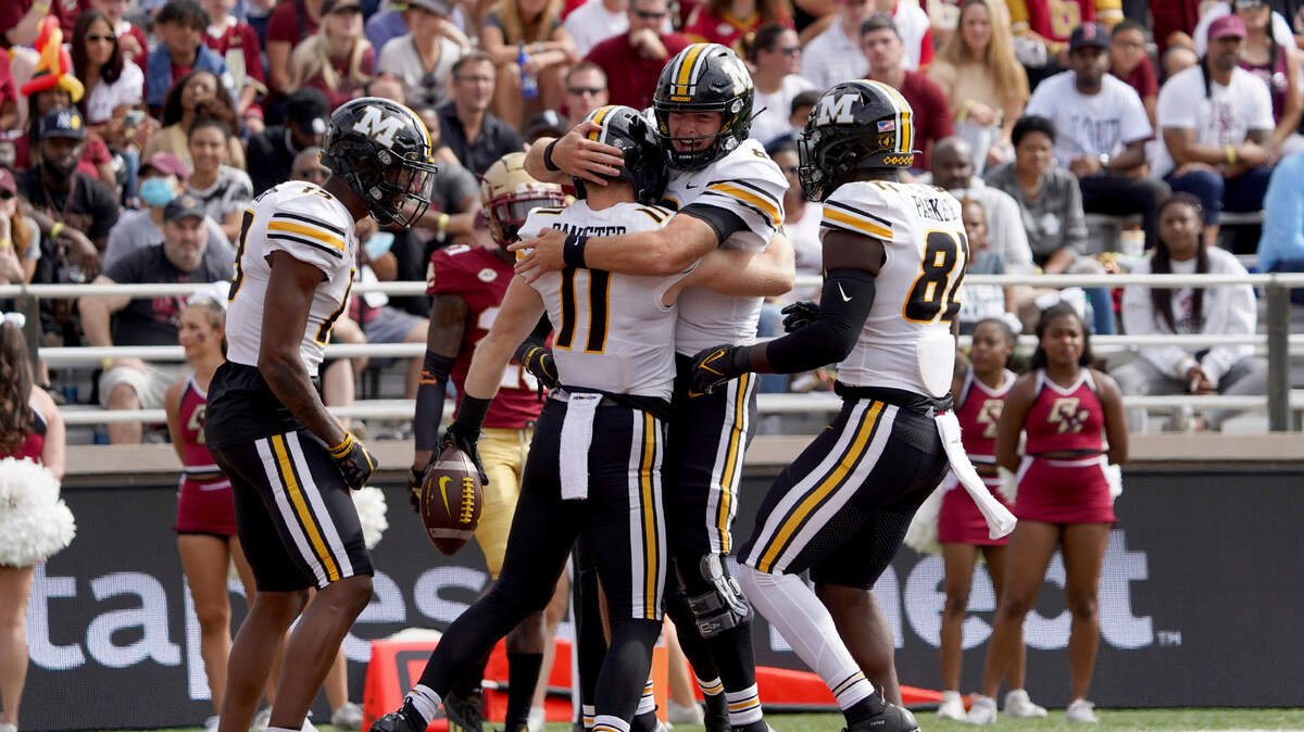 Missouri quarterback Connor Bazelak, facing, congratulates teammate Barrett Banister (11) after Bannister scored a touchdown in the first half of an NCAA college football game against Boston College, Saturday, Sept. 25, 2021, in Boston. (AP Photo/Mary Schwalm)