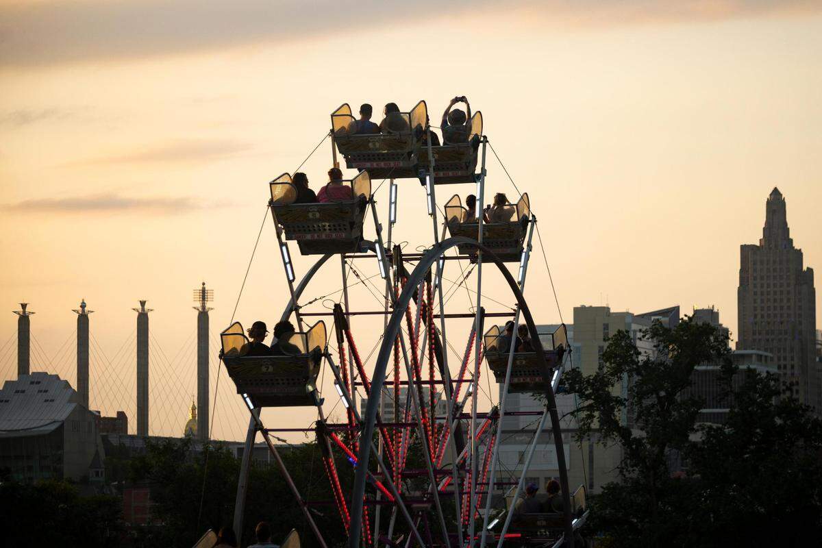 People ride the Ferris wheel at Crown Center during Boulevardia early in the evening of June 18, 2022, in Kansas City.