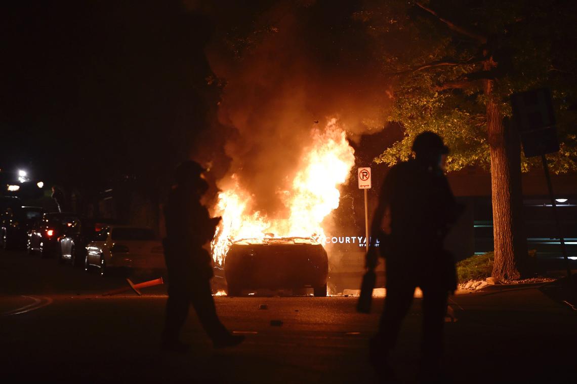 A Kansas City Police Department police car burns after a protester set it on fire during protests Saturday night at the Country Club Plaza. A protest meant to bring awareness to the death of George Floyd while in custody of Minneapolis police turned violent when stores and the police car became targets.