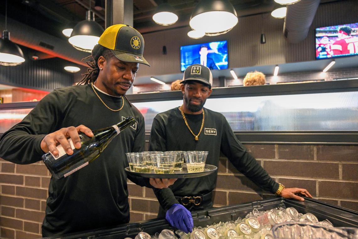 Bartender Abram Clay, left, and Jesse Bell, a bar back, ready the champagne during a soft opening Thursday at Serv.