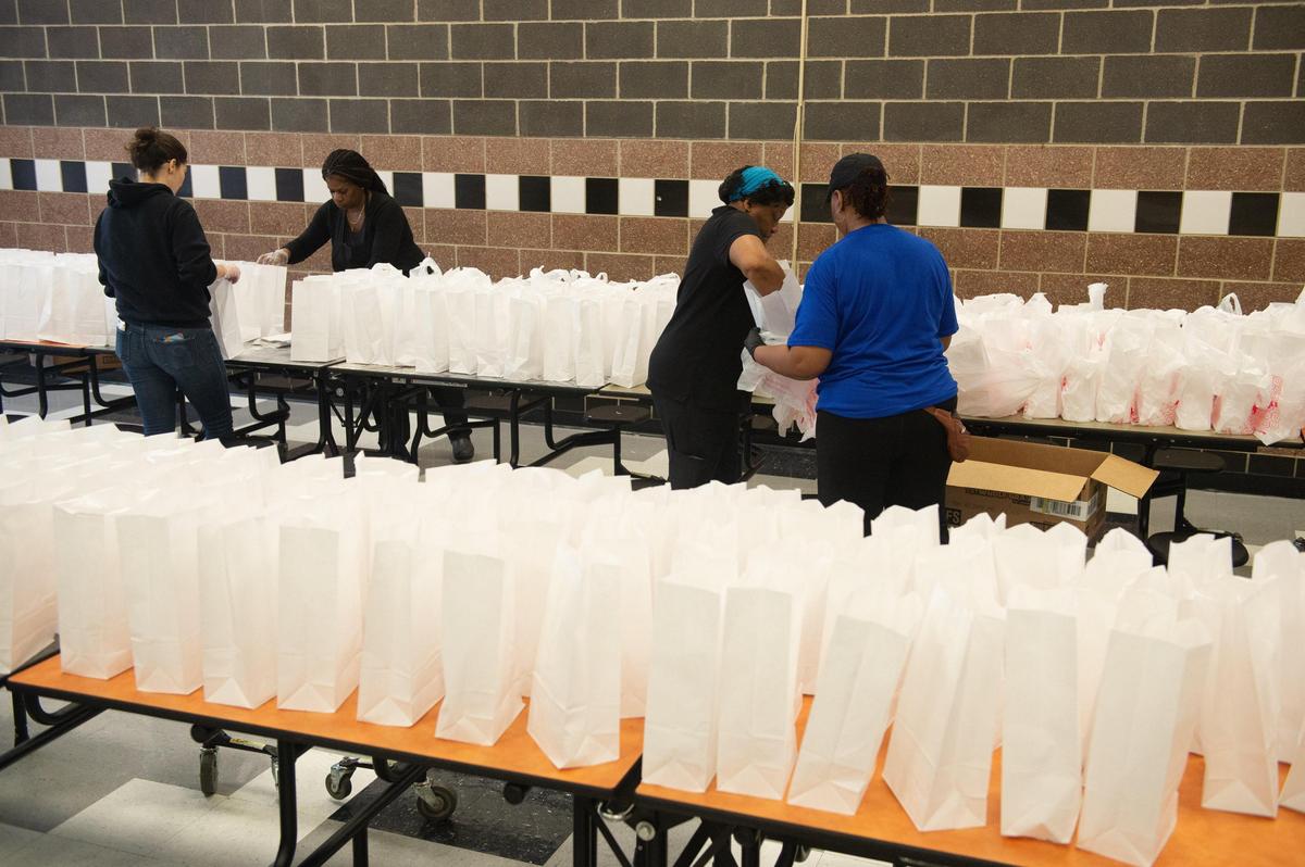 Kansas City Public Schools food service workers give up their spring breaks and pack sack meals at the district’s central kitchen at Paseo High School to feed thousands of students amid COVID-19 school closures.