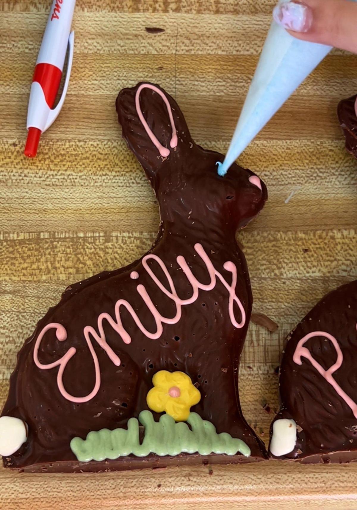 Laura Logan pipes an eye on a personalized handmade chocolate Easter bunny at Laura Little’s Candies.