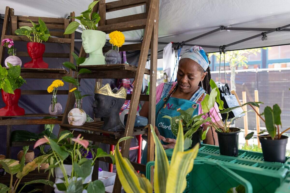 Connie Wells, co-owner of Wells Grown waters a plant behind the counter during JuneteenthKC 15th Annual Heritage Festival at E 18th Street on Saturday, June 20, 2026.