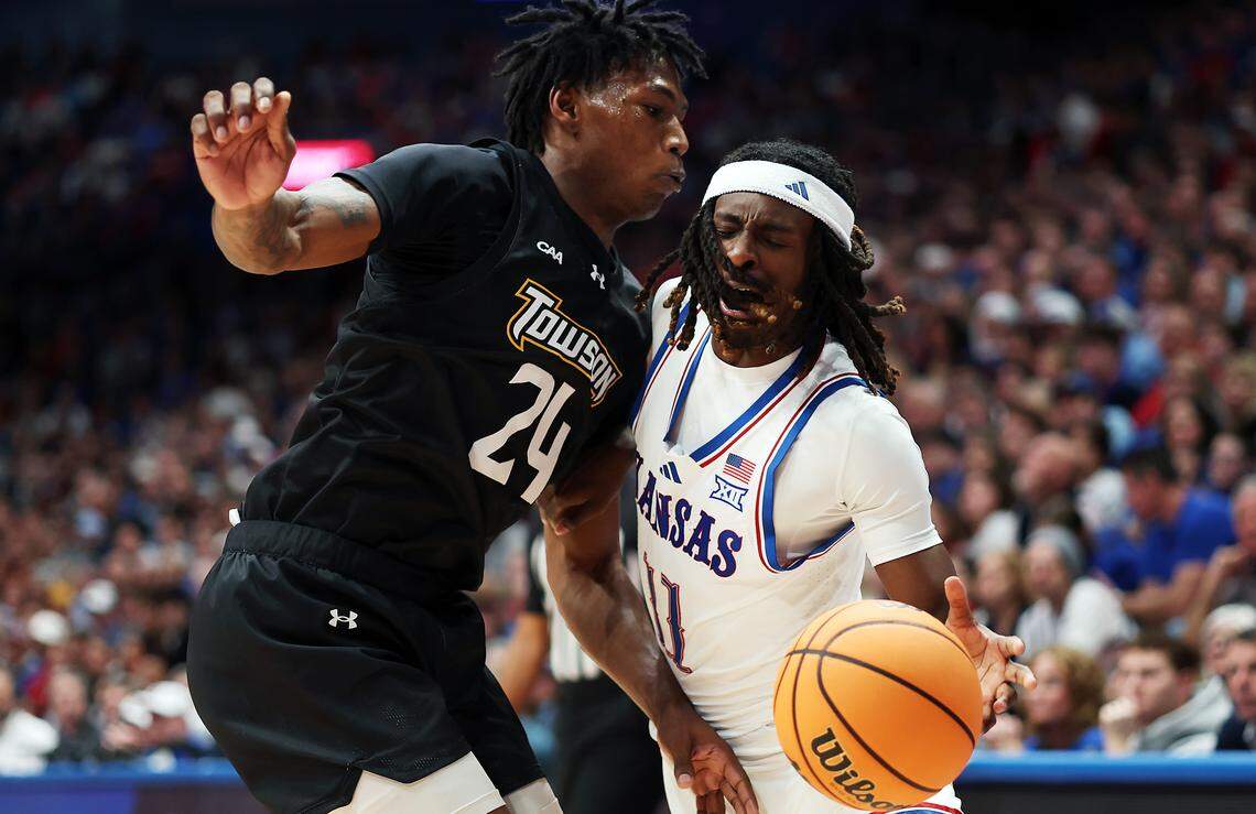 Jamari McDowell #11 of the Kansas Jayhawks drives with the ball as Jaquan Womack #24 of the Towson Tigers defends during the game at Allen Fieldhouse on December 16, 2025 in Lawrence.