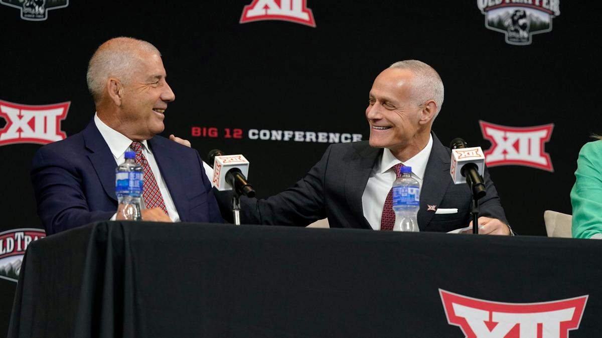 Incoming Big 12 Commissioner Brett Yormark, right, shares a laugh with outgoing Commissioner Bob Bowlsby at a news conference opening the NCAA college football Big 12 media days in Arlington, Texas, Wednesday, July 13, 2022. (AP Photo/LM Otero)