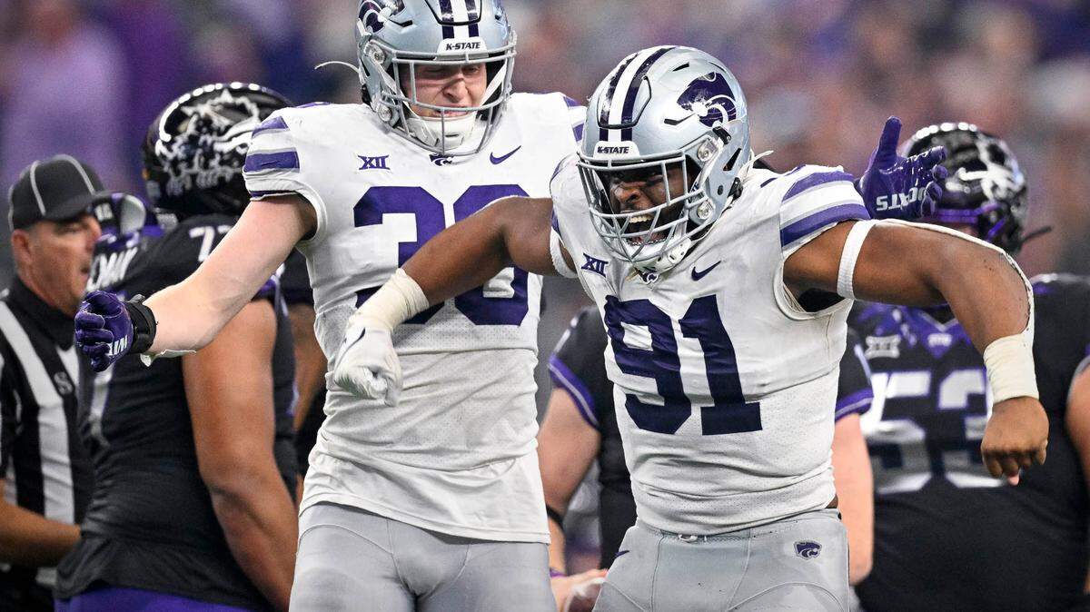 Kansas State Wildcats defensive end Felix Anudike-Uzomah (91) and defensive end Brendan Mott (38) celebrate after Anudike-Uzomah sacks TCU Horned Frogs quarterback Max Duggan (15) during the second half at AT&T Stadium.
