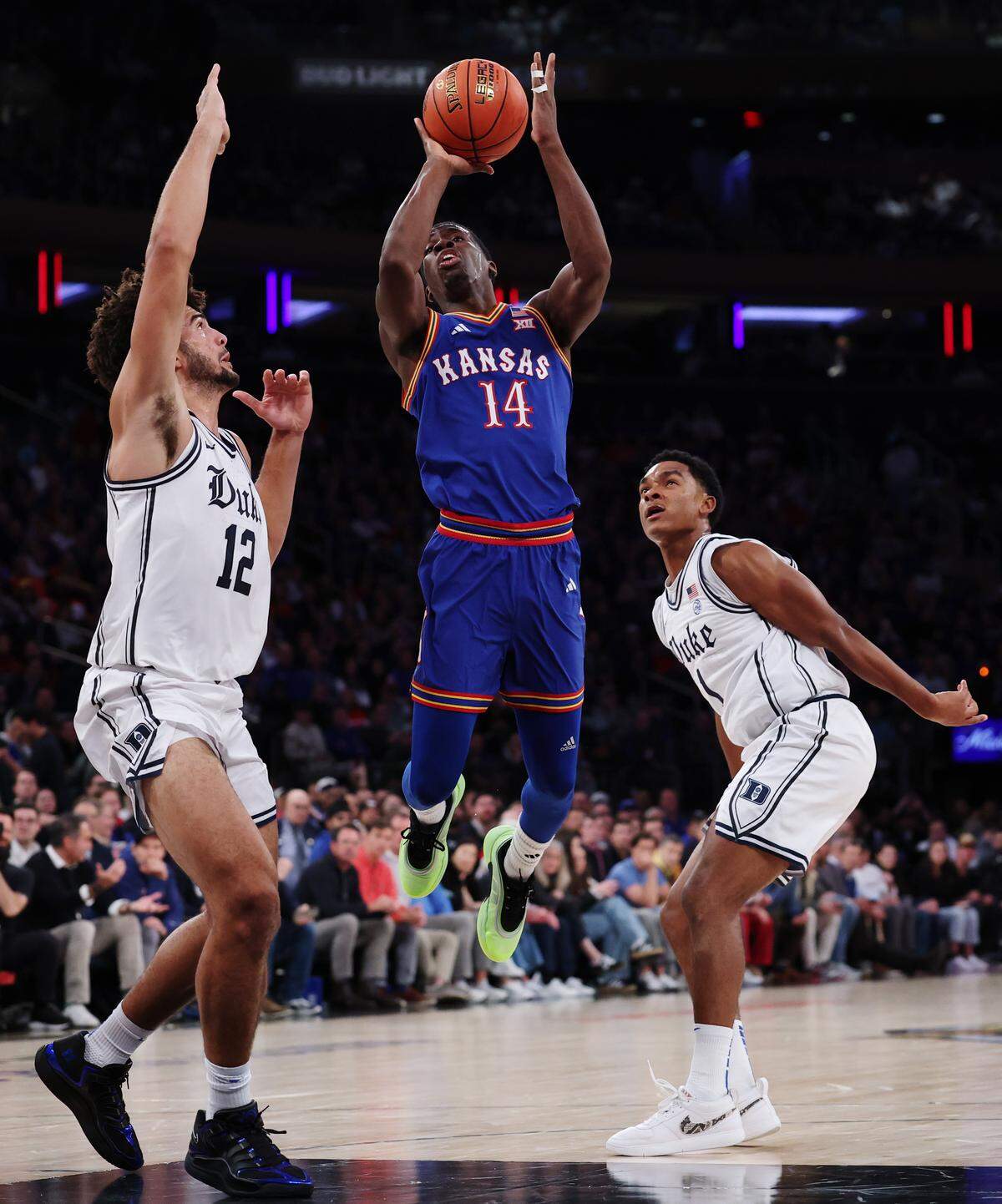 Melvin Council Jr. #14 of the Kansas Jayhawks goes to the basket as Cameron Boozer #12 and Caleb Foster #1 of the Duke Blue Devils defend during the first half in the 2025 State Farm Champions Classic at Madison Square Garden on November 18, 2025 in New York City.