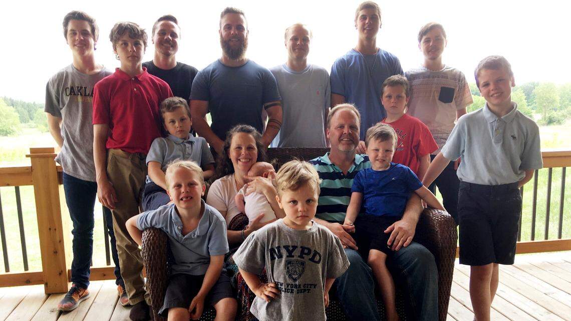 In a photo from May 30, 2018, the Schwandt family poses for a photo at their farm in Lakeview, Mich. Standing from left are Tommy, Calvin, Drew, Tyler, Zach, Brandon, Gabe, Vinny and Wesley. Seated, starting at upper left are Charlie, Luke, mother Kateri holding Finley, father Jay with Tucker and Francisco in the foreground.
