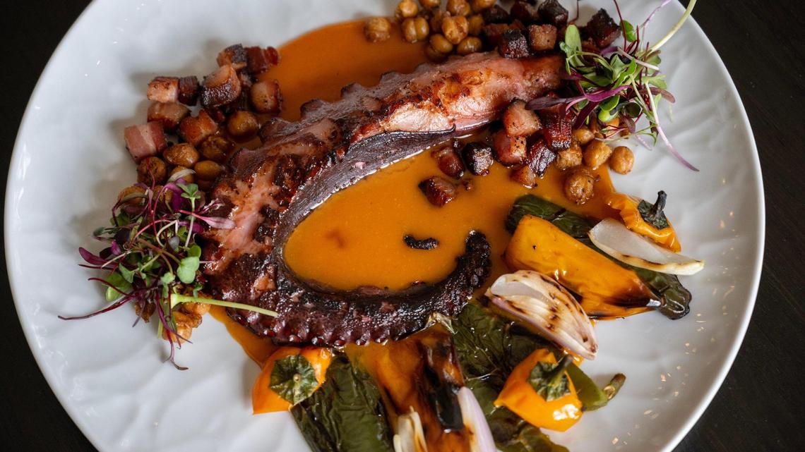 Aqua Penny’s fire-roasted octopus and peppers, featues charred octopus, sweet peppers, jalapeños, shallots, lardons and crispy chickpeas, finished with red pepper coulis.