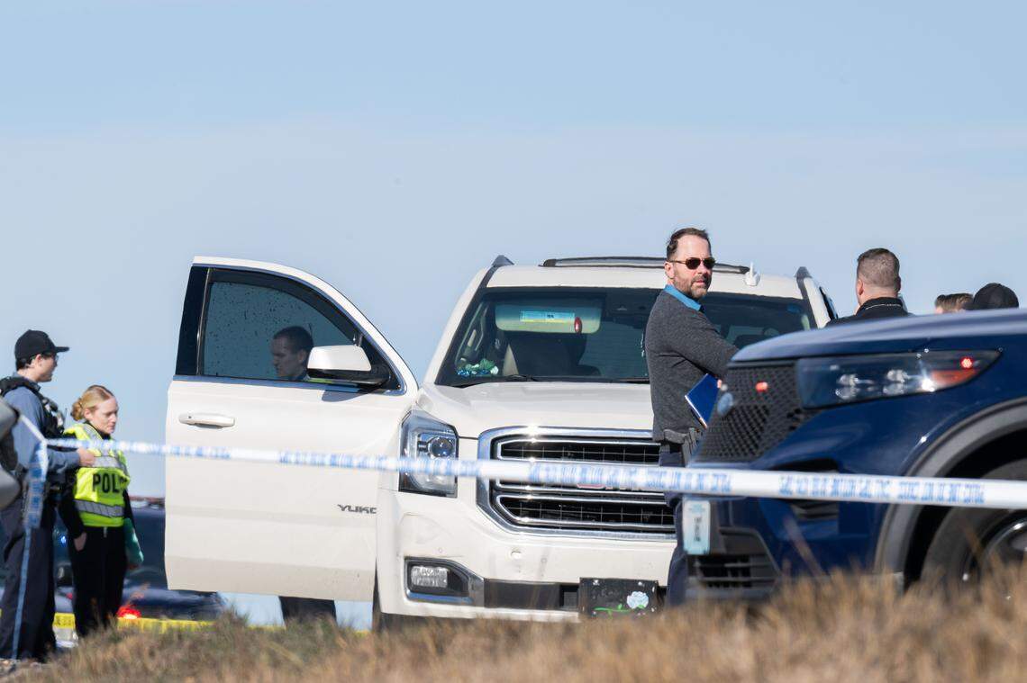 Police surround a white SUV after an alleged murder on Southbound 71 Highway and Blue River Road on Wednesday, January 7, 2026. Traffic was being diverted as the section of the highway remains closed.