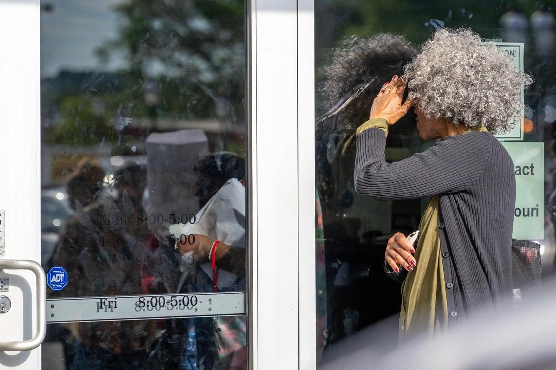 A person peers through the window while waiting in line outside the Kansas City DMV on Wednesday, May 7, 2025, in Kansas City. The line formed early as the office reached capacity, with many waiting to apply for Real IDs.