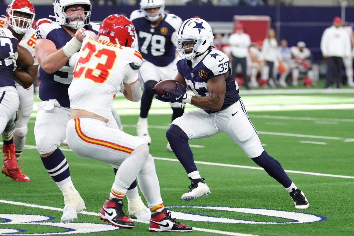 Javonte Williams of the Dallas Cowboys, right, carries the ball against the Kansas City Chiefs during an NFL Week 13 Thanksgiving Day game at AT&T Stadium in Arlington, Texas on Thursday, Nov. 27, 2025.