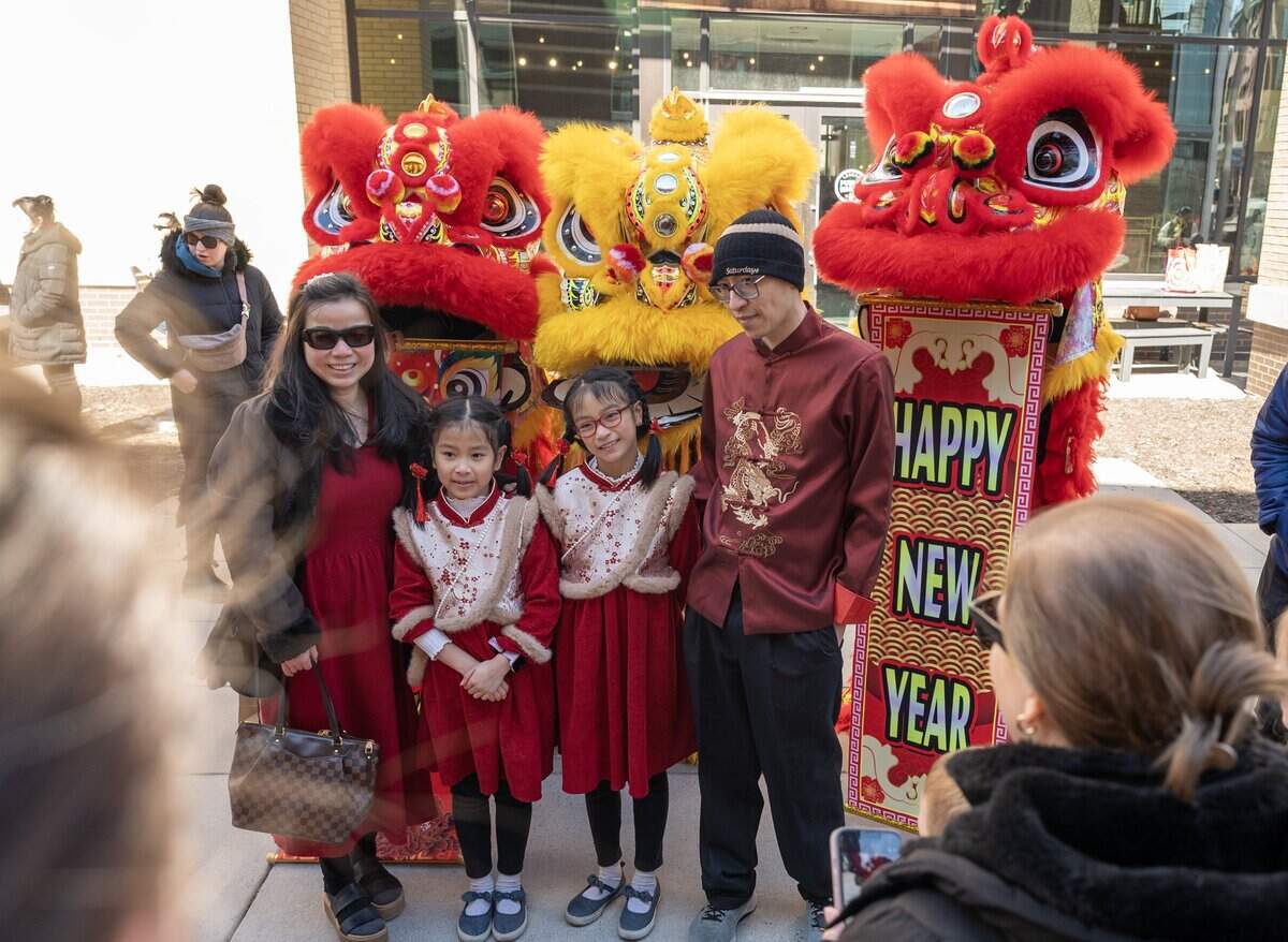 Families pose for photos with the Th?n Phúc Lion Dance team after a performance during a Lunar New Year celebration at the Lenexa Public Market on Sunday, Feb. 22, 2026, in Lenexa, Kan.