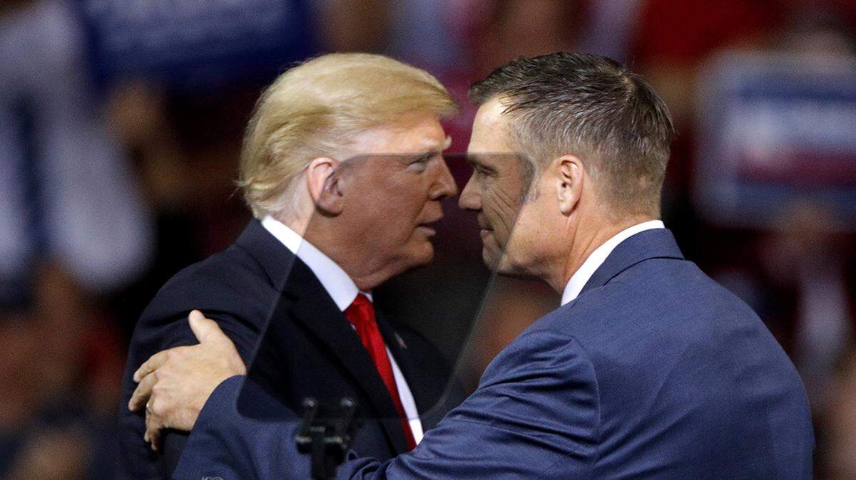 President Donald Trump greets Republican candidate for Kansas Gov. Kris Kobach during a campaign rally Saturday, Oct. 6, 2018, in Topeka, Kansas.