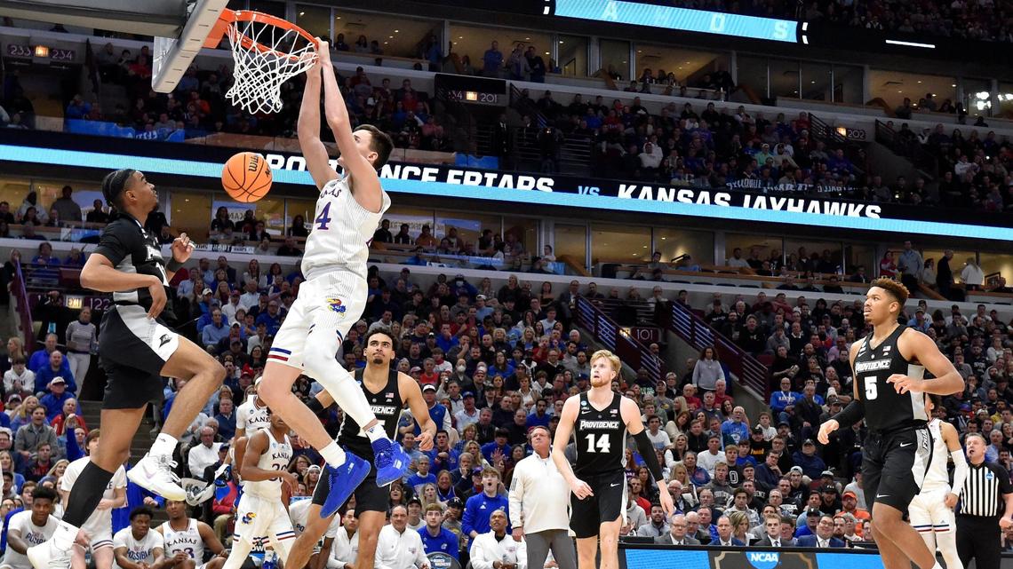 KU’s Mitch Lightfoot throws down a dunk over Providence’s A.J. Reeves during the second half of the Jayhawks 66-61 win over Providence Friday night in a third round game of the NCAA Tournament at the United Center in Chicago.