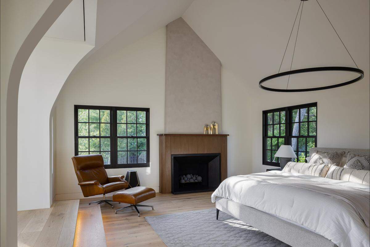 The master bedroom inside the home at 5930 Oakwood Road features its own fireplace, an integrated dropdown TV and an en-suite bathroom.