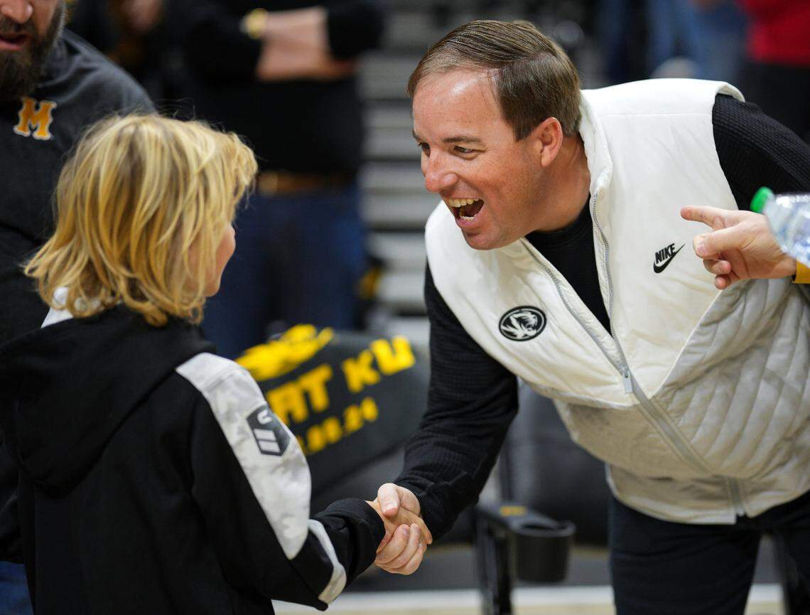 Missouri Tigers football coach Eliah Drinkwitz greets a young fan at Mizzou Arena before tipoff of the MU-KU game on Sunday, Dec 8, 2024 in Columbia, Missouri.