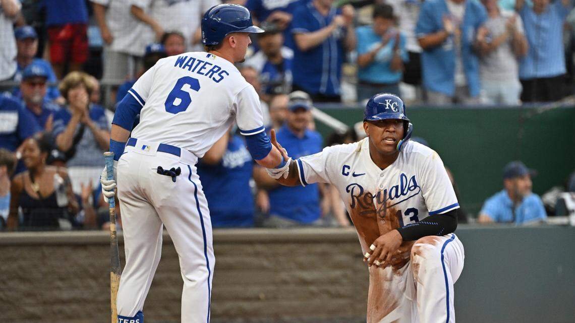 Royals center fielder Drew Waters helps up catcher Salvador Perez after scoring a run in the first inning against the Los Angeles Dodgers at Kauffman Stadium.