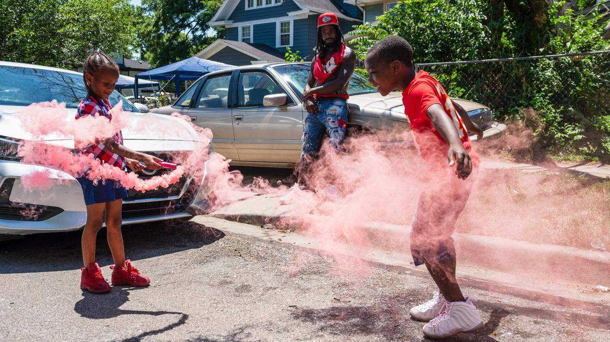 Cherish Swinton, left, Jaron Carter, and Knowledge Thompson light of smoke bomb in the Oak Park Northwest neighborhood on Tuesday, July 4, 2023, in Kansas City. Residents of the Oak Park Northwest neighborhood celebrated the Fourth of July with block parties and barbecues throughout the area.