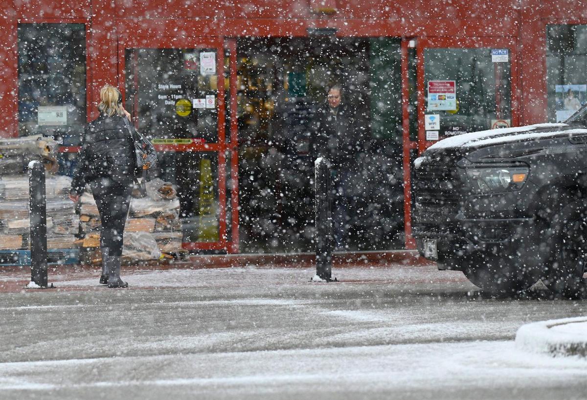 Visibility was a bit limited as snow fell and began to accumulate on the ground as shoppers headed to a grocery store in Lenexa, Kansas, on Friday, Jan. 5, 2024.