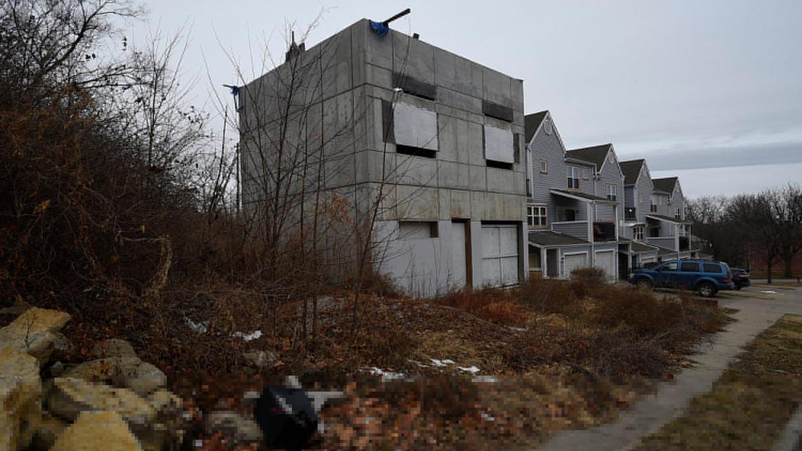 What was meant to be a modern concrete house has, over the last five years, turned into what neighbors call a concrete eyesore. Thousands of drivers a day pass the hollow, unfinished carcass of the two-story gray concrete house just west of Southwest Trafficway.
