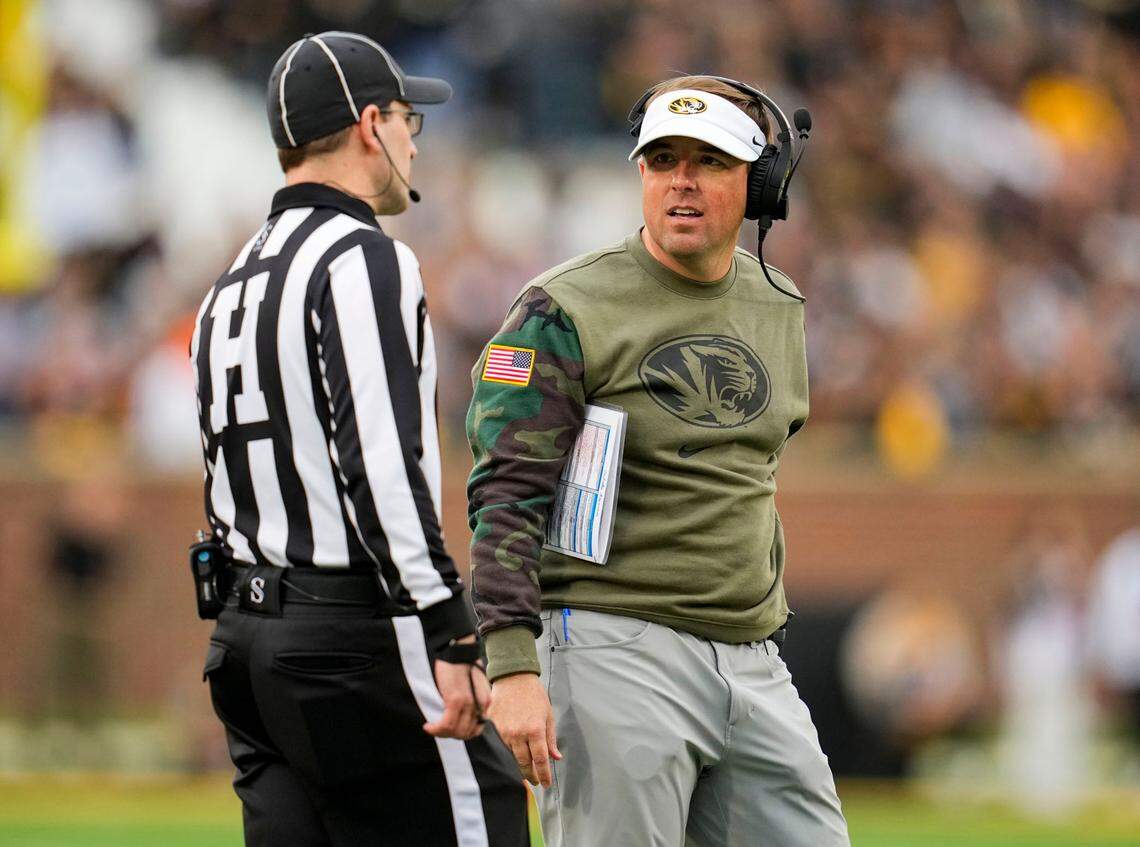Missouri Tigers football coach Eliah Drinkwitz talks with head linesman Carl Gioia during Saturday’s game against the Tennessee Volunteers at Faurot Field.