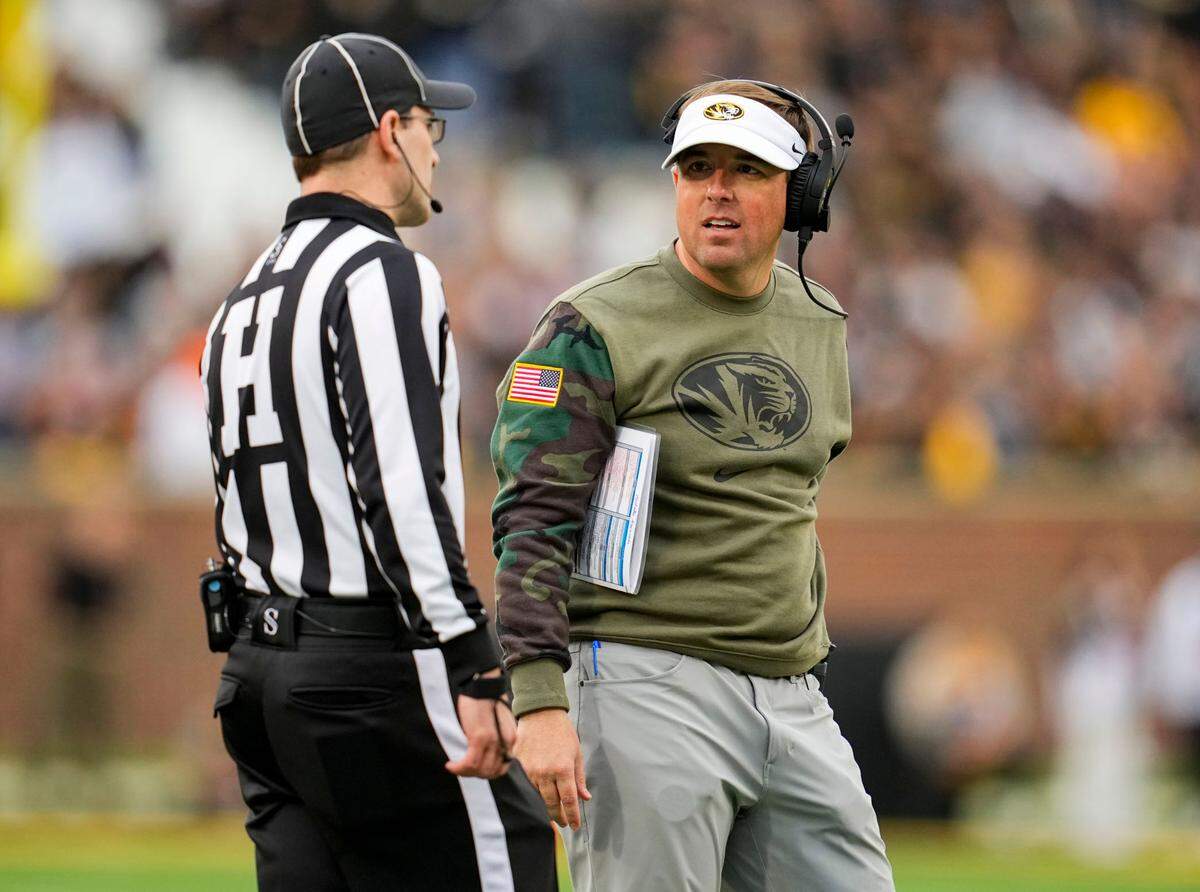 Missouri Tigers football coach Eliah Drinkwitz talks with head linesman Carl Gioia during Saturday’s game against the Tennessee Volunteers at Faurot Field.