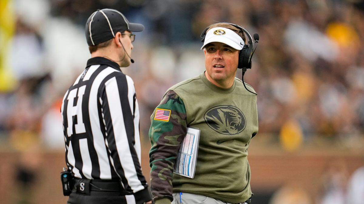 Missouri Tigers football coach Eliah Drinkwitz talks with head linesman Carl Gioia during a game against the Tennessee Volunteers at Faurot Field.