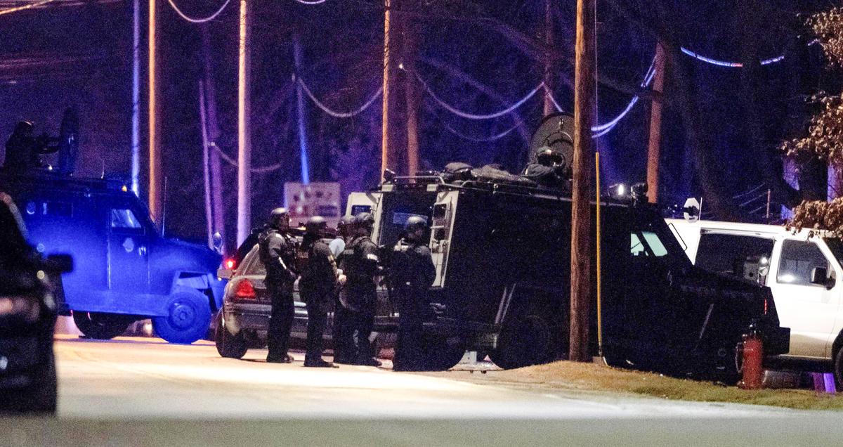 KCPD SWAT officers stand behind a Bearcat tactical vehicle during a standoff in the 2300 block of Blue Ridge Boulevard on Tuesday, Feb. 28, 2023, in Kansas City. Three officers have been shot and police remain in a standoff with the suspect.
