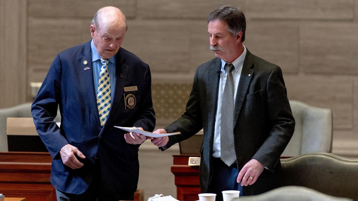 State Sen. Mike Moon, an Ash Grove Republican, right, hands doorkeeper Gil Schellman, left, copies of a proposed bill on Tuesday, March 7, 2023, at the state Capitol in Jefferson City, Mo.
