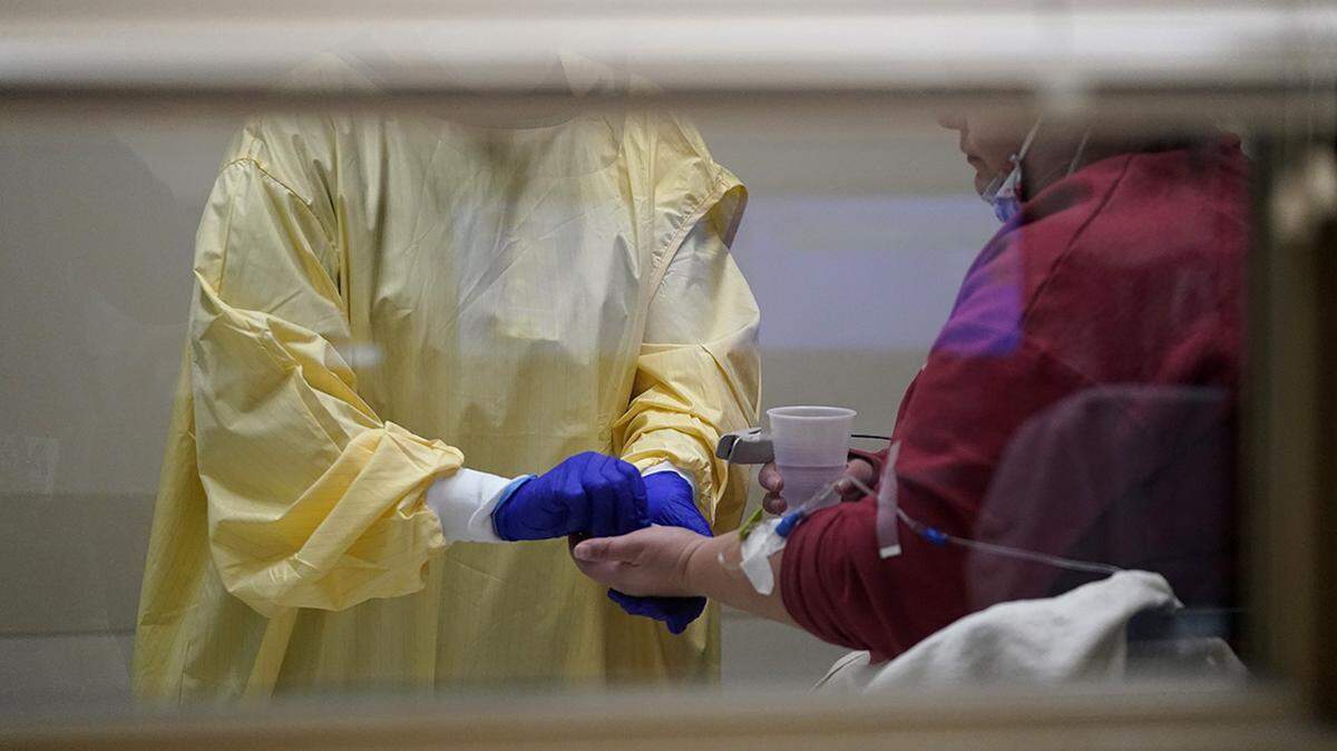 A registered nurse hands medication to a COVID-19 patient inside the emergency room at Scotland County Hospital in Memphis, Missouri.