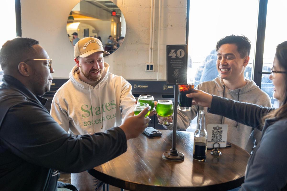 Kalyn Ahrens, center, toasts with friends while attending the Pandan Coconut Doughnut Ale release party at Boulevard Brewing Tours and Recreation Center on Sunday, March 9, 2025, in Kansas City.