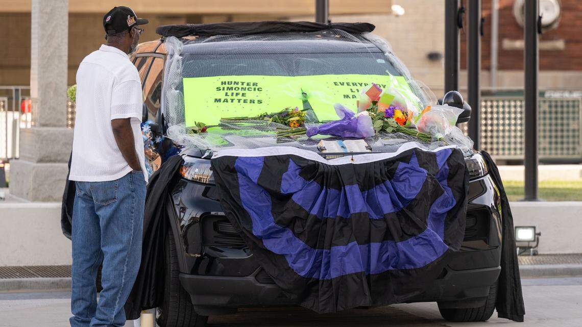 People stop to view the police cruiser driven by slain KCKPD officer Hunter Simoncic set up as a memorial in front of Kansas City, Kansas City Hall on Wednesday, Aug. 27, 2025.