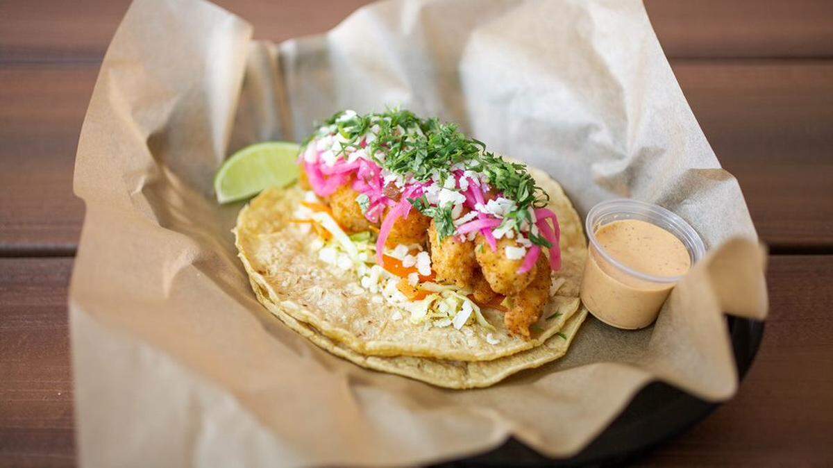 Torchy’s Tacos’ Baja Shrimp taco with fried shrimp, cooked cabbage slaw, pickled onions and jalapenos, cotija cheese, cilantro and lime wedge with chipotle sauce on a corn tortilla.