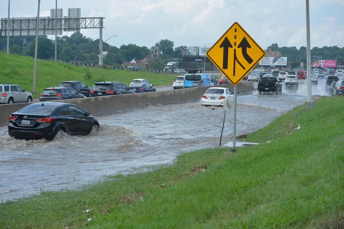 Cars splash through floodwater on the Southwest Trafficway on ramp to northbound Interstate 35 heading toward downtown Kansas City, Wednesday after heavy rains flooded the area. The interstate was impassible for a while due to water pooling in the lanes.