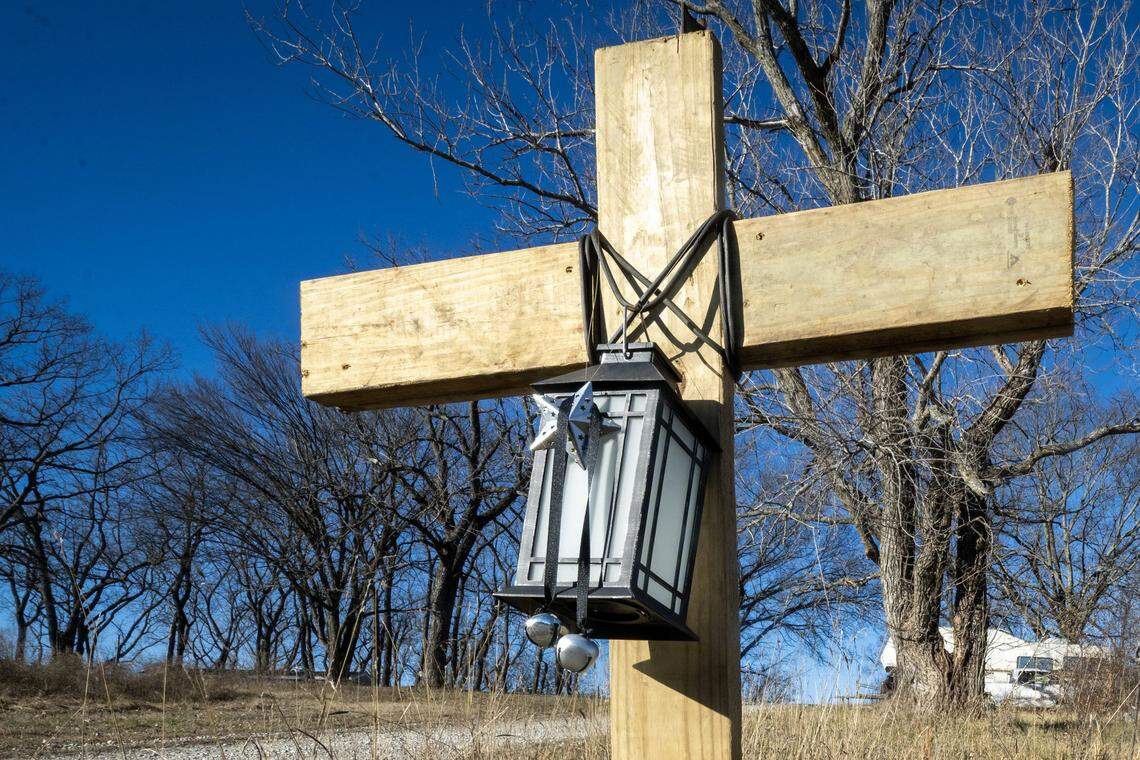A cross adorned with a solar lantern honors the memory of Airen Andula, 13, in the Holiday Lakes area of Pleasanton in Linn County, Kansas, on Monday, Jan. 12, 2026. The lantern was chosen because Airen was afraid of the dark. The cross was built by friends of Airen and erected near the area where friends believe Airen was attacked and killed by dogs on Dec. 22, 2025.