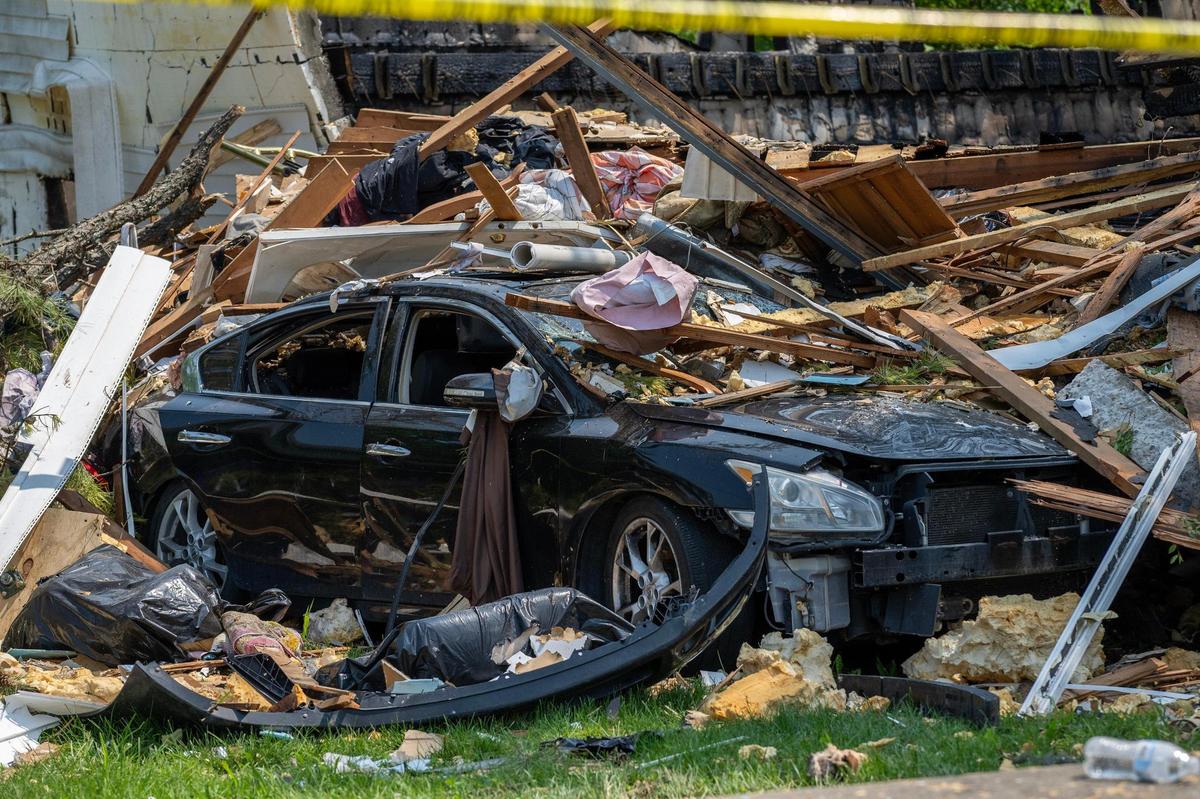 A vehicle damaged by debris sits in a driveway on Sunday, June 1, 2025, in Gladstone. The debris was scattered following a home explosion the day before that killed one person and damaged nearby houses.