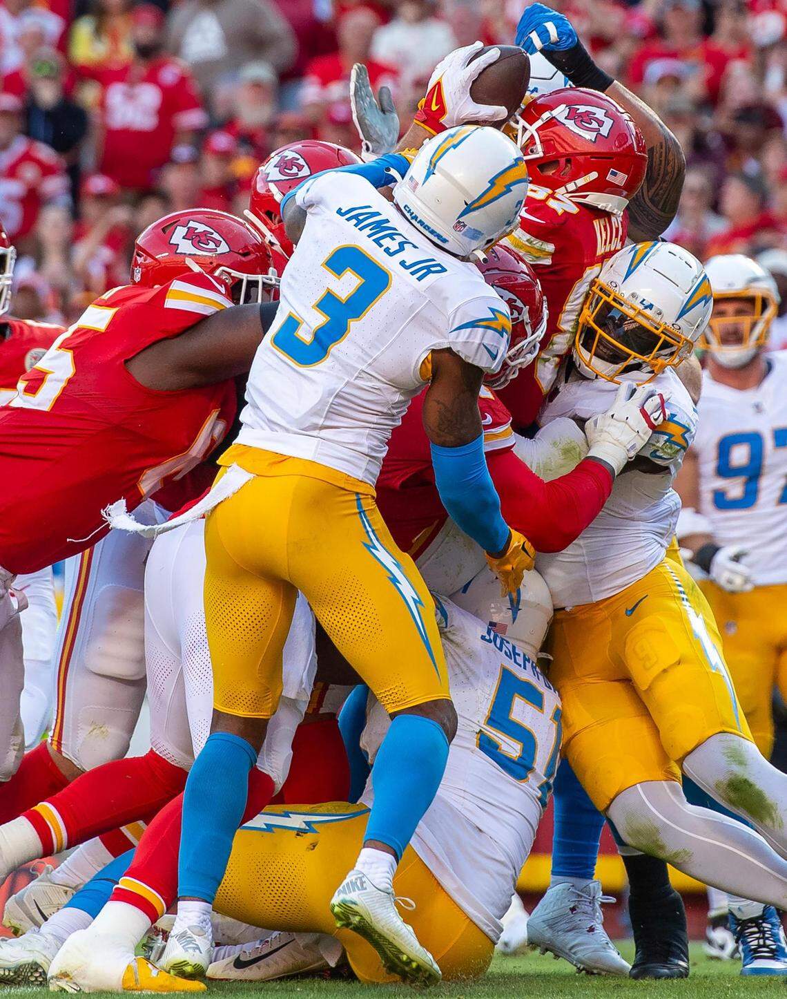 This is the first of five frames that captured the peak moment Travis Kelce was being pushed by his teammates into the end zone against the defensive force of several Chargers players. You can see the top of his helmet and the ball but his face is blocked by Los Angeles Chargers safety Derwin James Jr. (3).