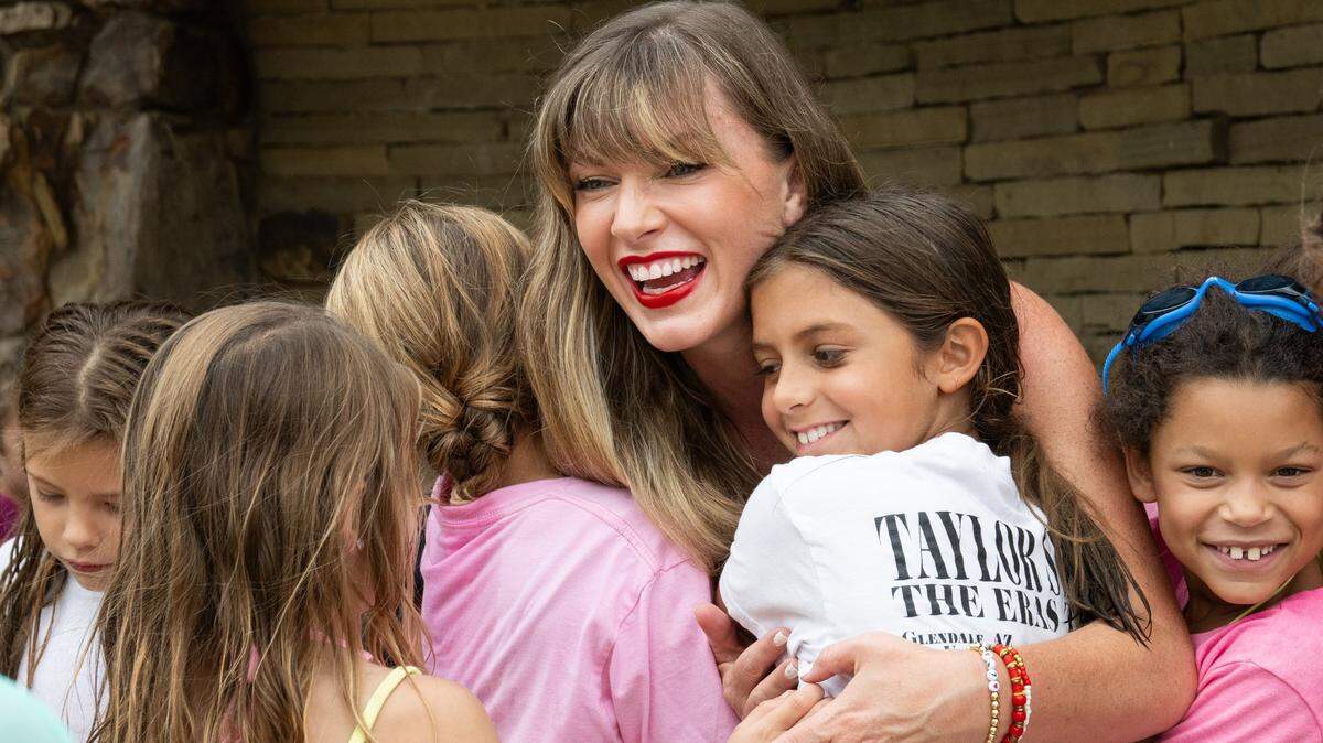Kelley Thrasher of Johnson County, a full-time nanny, hugs kids at a birthday party in Olathe earlier this month. She has become a popular Taylor Swift tribute artist in Kansas City.