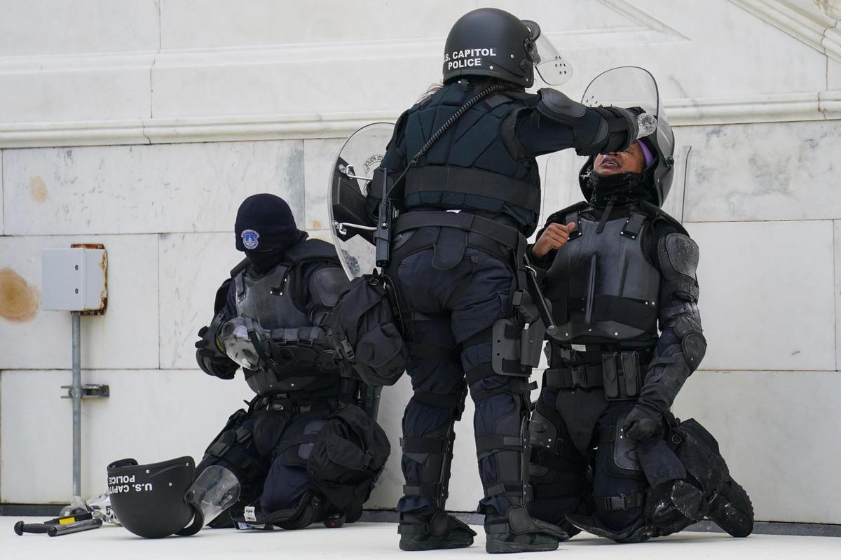 A police officer has eyes flushed with water after a confrontation with demonstrators, Wednesday, Jan. 6, 2021, at the Capitol in Washington. As Congress prepares to affirm President-elect Joe Biden’s victory, thousands of people have gathered to show their support for President Donald Trump and his claims of election fraud.(AP Photo/John Minchillo)