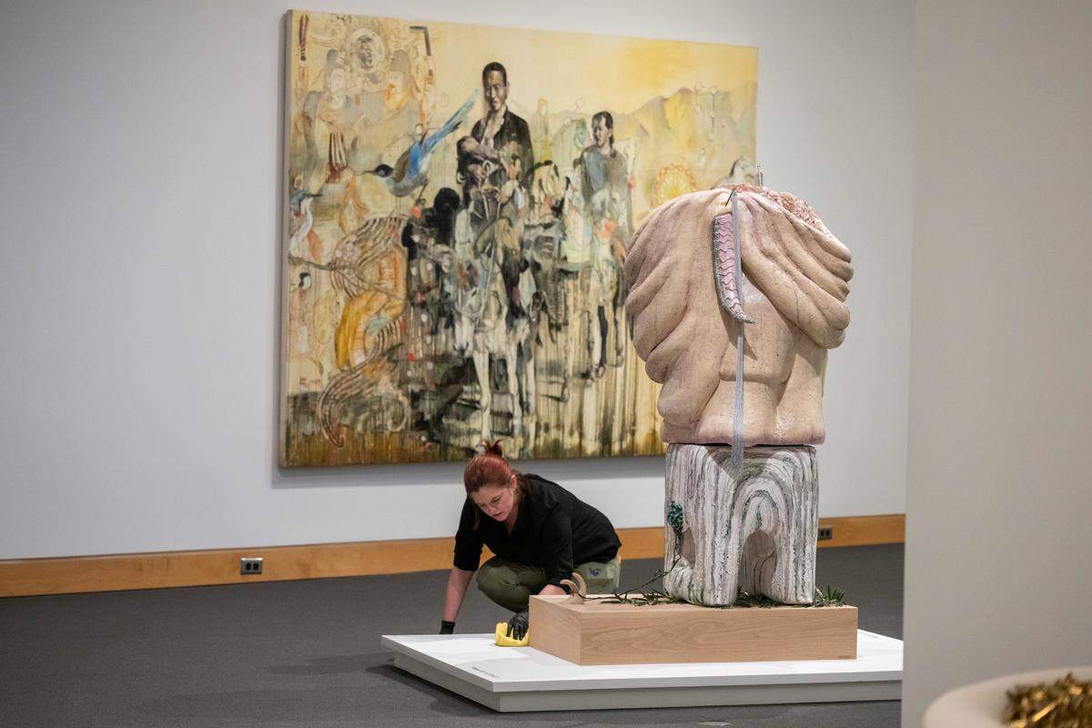 In a March 5, 2026 photo, Carley Roche wipes down surfaces before the opening of The World in Kansas City, an exhibition showcasing work from artists who have connections to Kansas City, at the Kemper Museum of Contemporary Art.