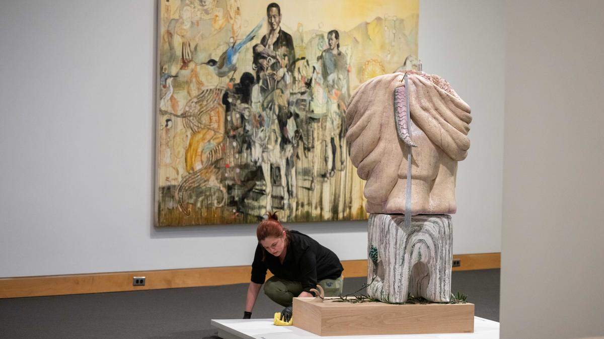 Carley Roche wipes down surfaces before the opening of “The World in Kansas City,” an art exhibition showcasing work from artists' that have connections to Kansas City, on Thursday, March 5, 2026, at the Kemper Museum of Contemporary Art.
