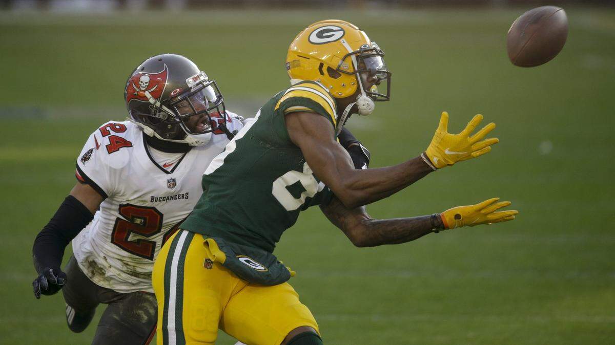 Then with the Green Bay Packers, wide receiver Marquez Valdes-Scantling, right, makes a 50-yard touchdown catch against the Tampa Bay Buccaneers during the January 2021 NFC Championship Game at Lambeau Field.