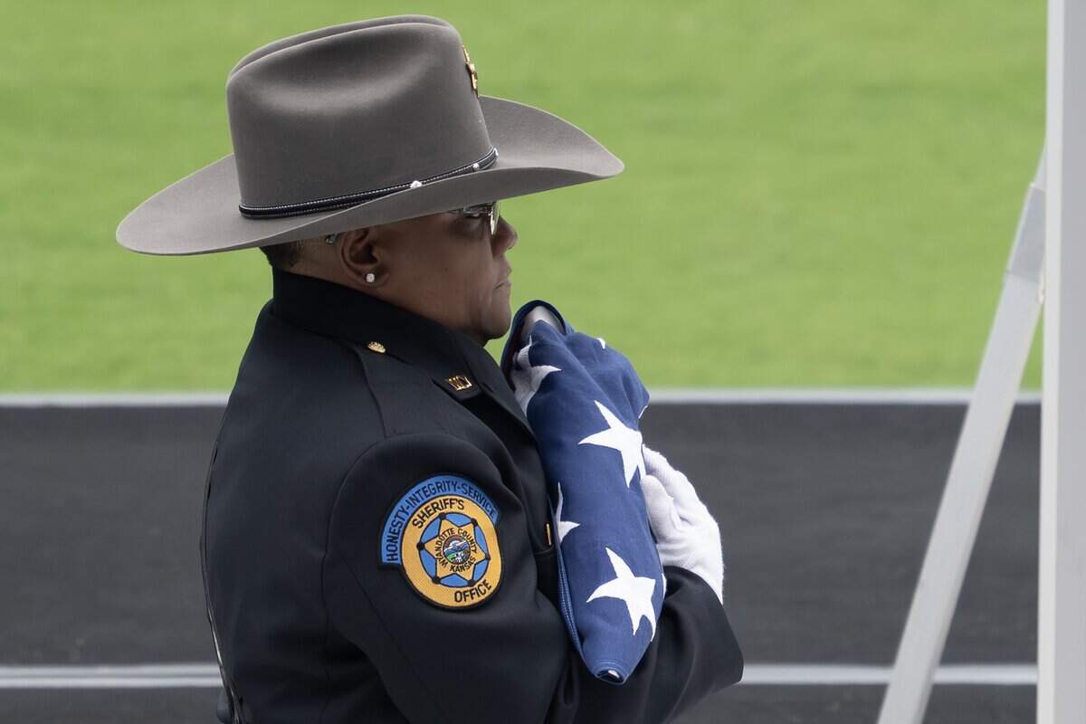 First responder walks with the U.S. flag from Deputy Elijah Ming's coffin during the flag presentation ceremony held at Children's Mercy Park on Monday, Aug. 11, 2025, in Kansas City, Kansas.