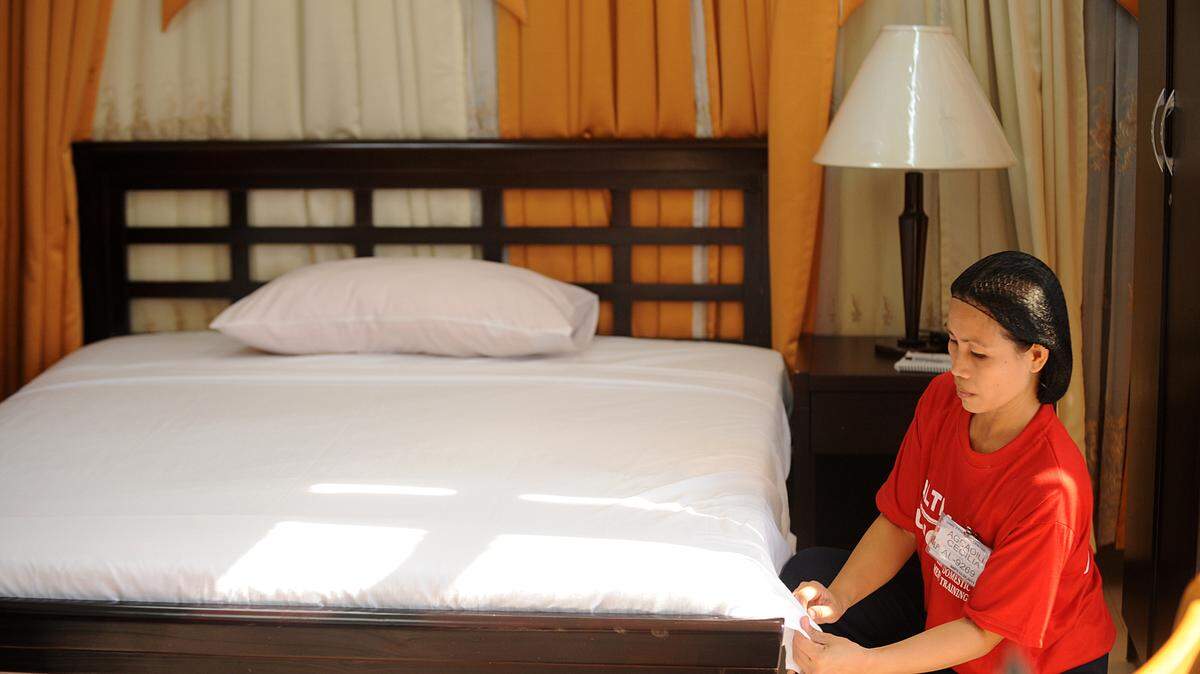 Woman cleaning bedroom.