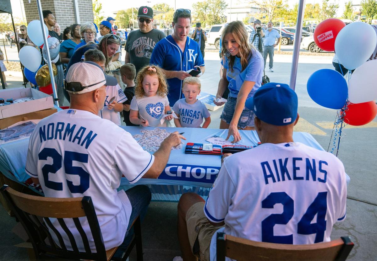 Former Royals players Les Norman, left, and Willie Mays Aikens greeted Royals fans Matt and Rachel Roberts and their children, Giuliana, 7, and Anthony, 5, during Bring Out the Blue, a tailgating event featuring autographs, Royals swag, and free ice cream at the Price Chopper in Lee’s Summit on Monday, Sept. 30, 2024. The family is from Lee’s Summit. Aikens, who played first base, is remembered for hitting four home runs in the 1980 World Series with the Royals.