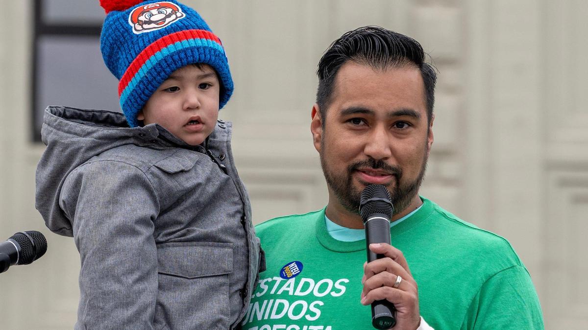Jackson County Legislator Manuel Abarca IV hold his son while speaking during a rally in support of federal workers on Wednesday, March 12, 2025, in Kansas City.